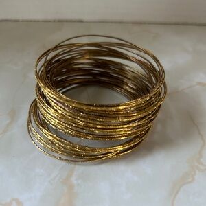 Gold tone Bangle set. Some show signs or wear , but there is 48 of them!